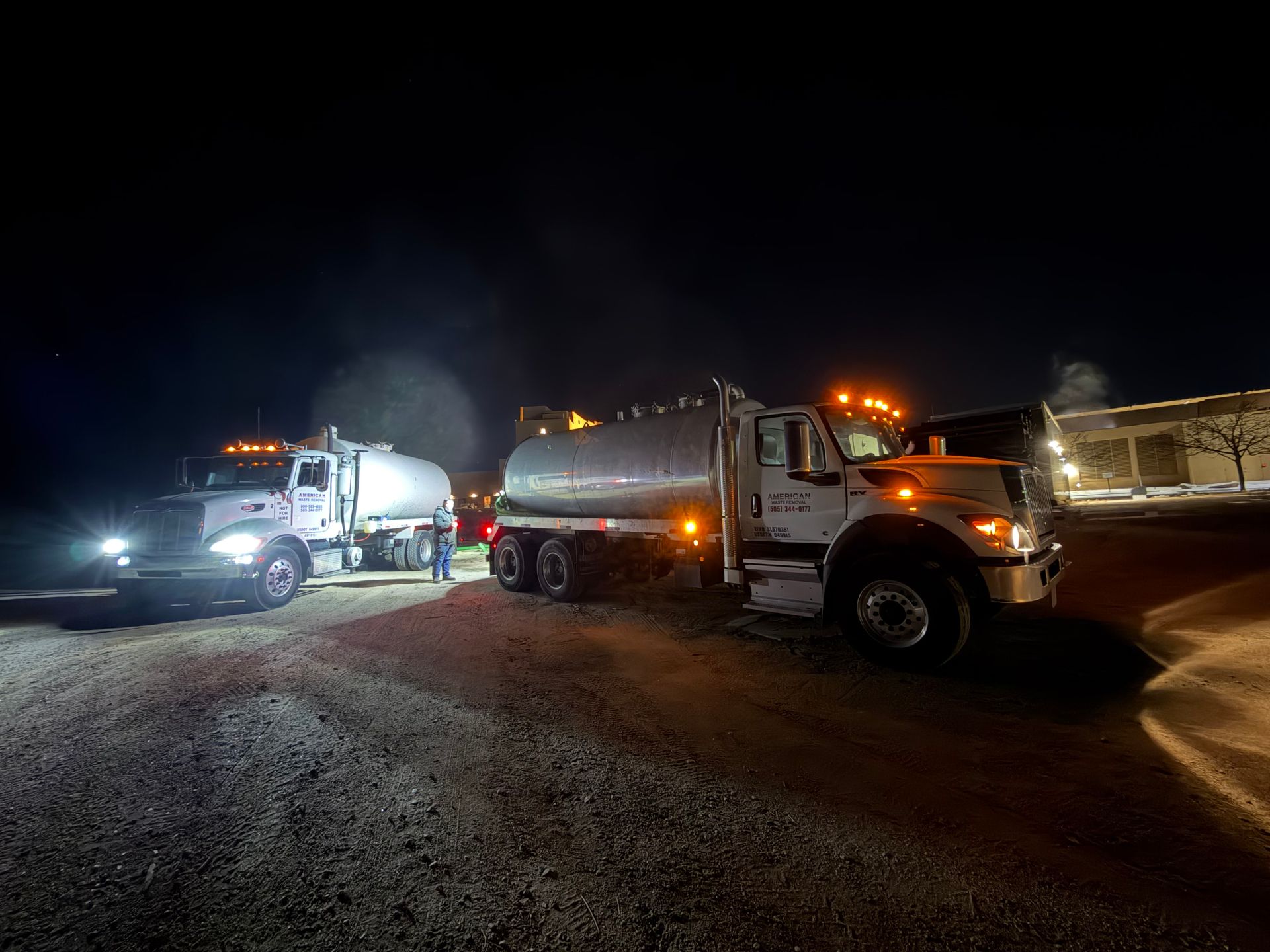 American Waste Removal grease trap service trucks working on site at night